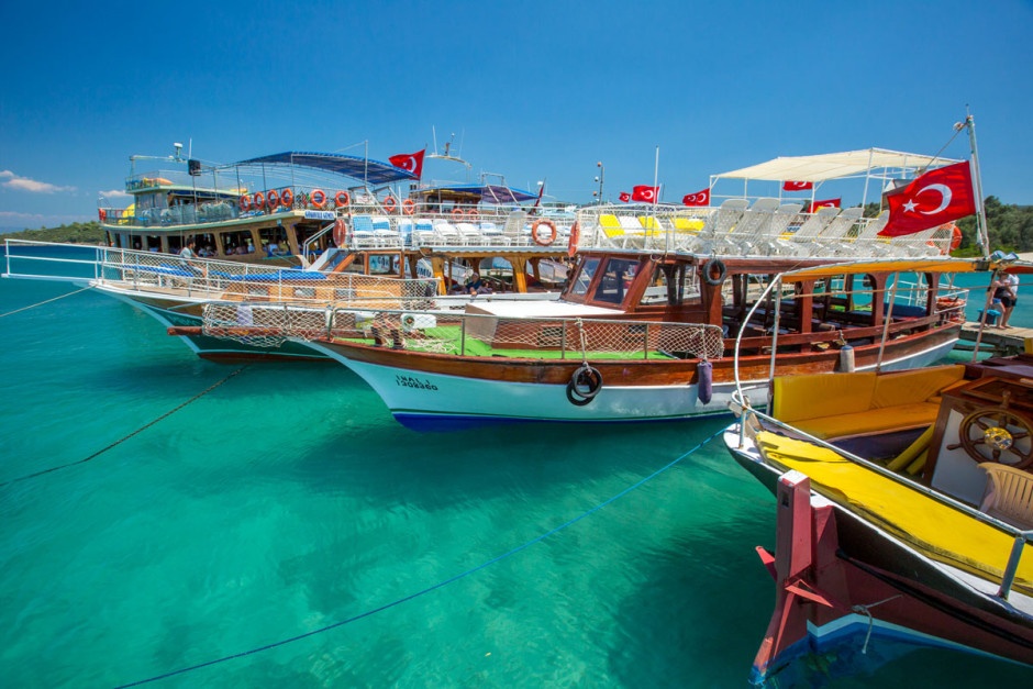 Những con tàu nhiều màu neo đậu trên làn nước trong vắt.