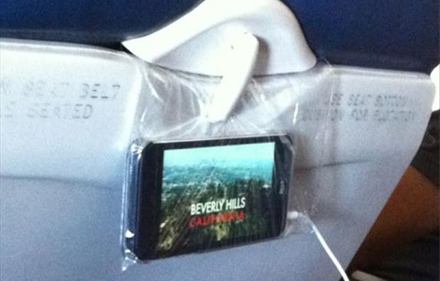 Dùng túi nylon để treo điện thoại: Cho điện thoại vào túi, kẹp miệng túi vào chiếc bàn gấp phía trước, thế là bạn đã có chiếc TV mini.