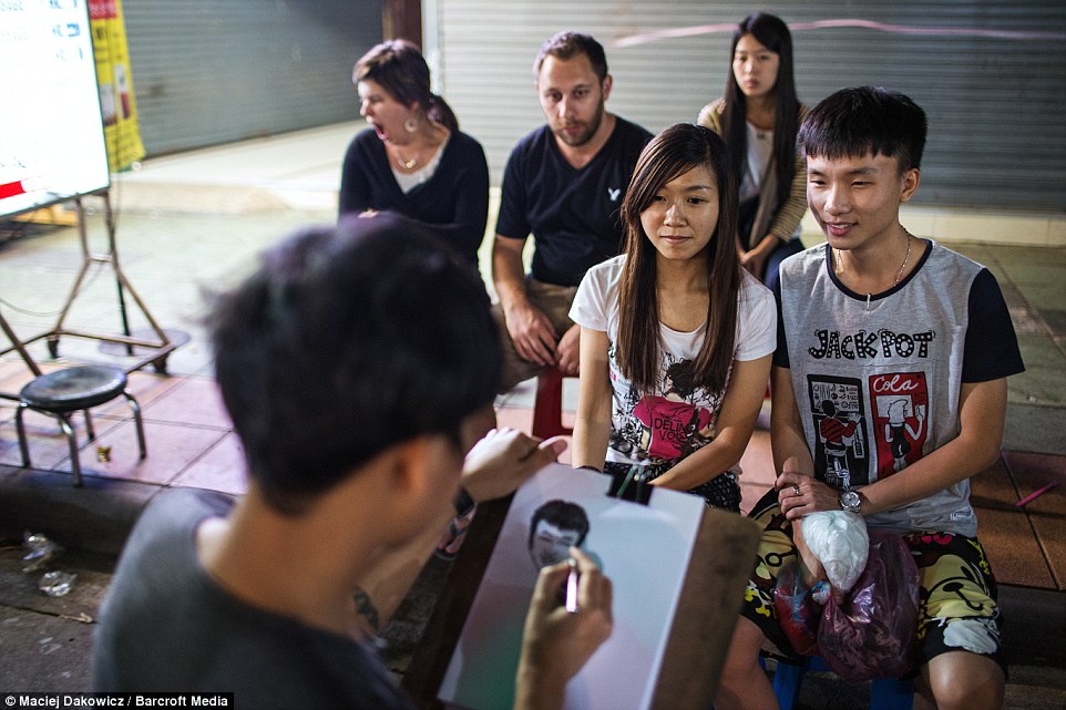 Ở một góc phố, người họa sĩ đang vẽ chân dung cho du khách.