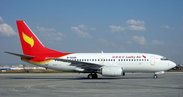 Them mot cu ba Trung Quoc nem tien xu vao dong co may bay hinh anh