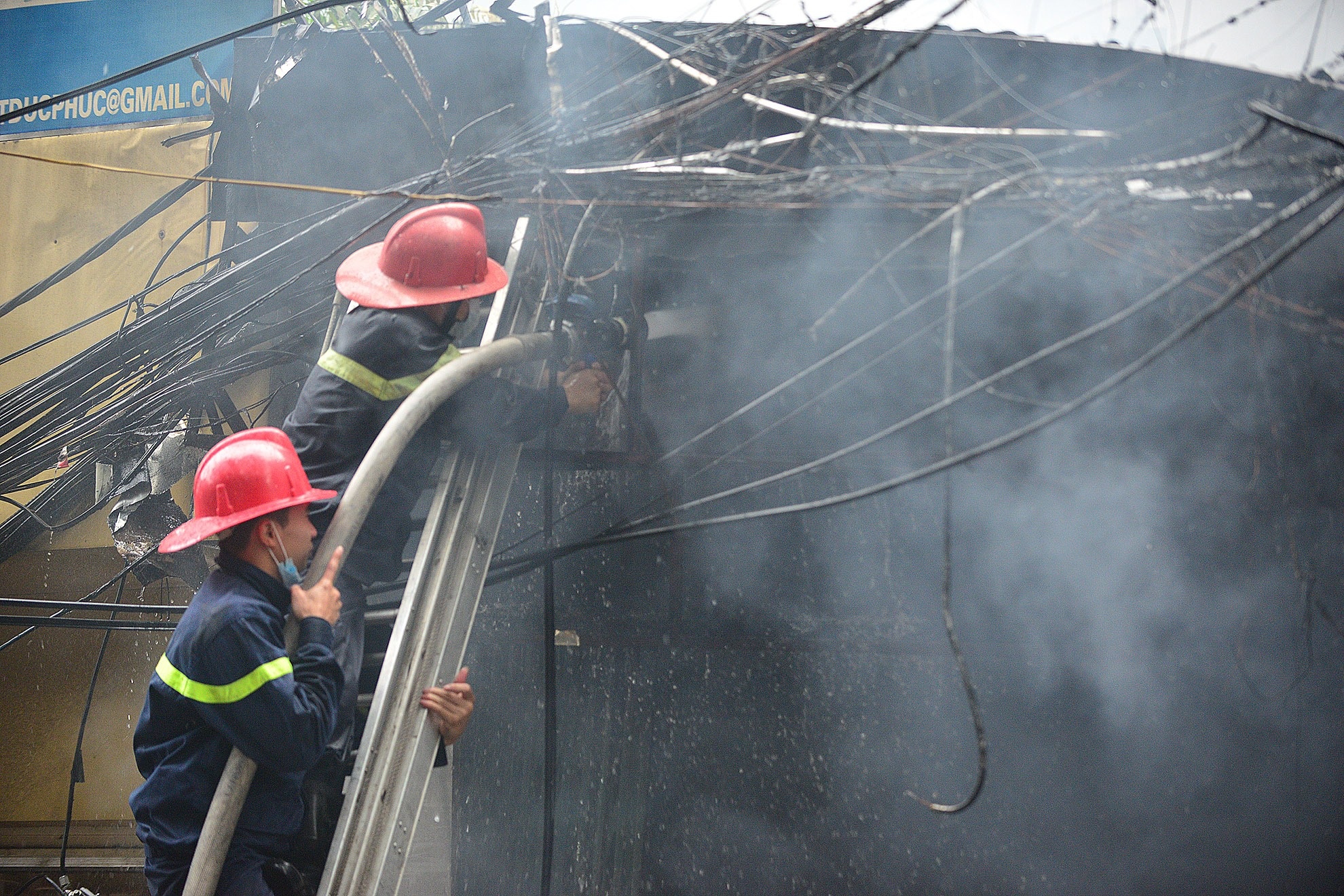 Lính cứu hỏa phải đập bỏ mái tôn bên ngoài để chữa cháy.