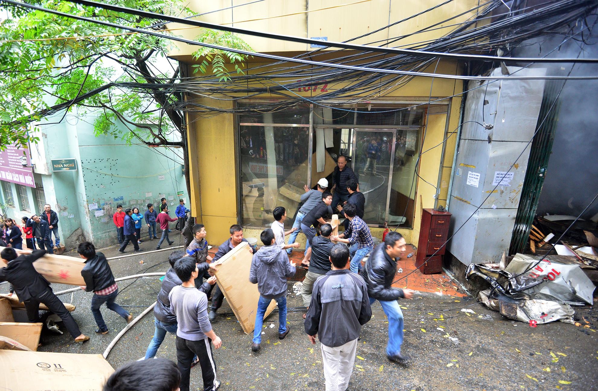 Cửa hàng bên cạnh bán đồ gỗ nội thất văn phòng nhanh chóng di chuyển đồ đạc ra ngoài.