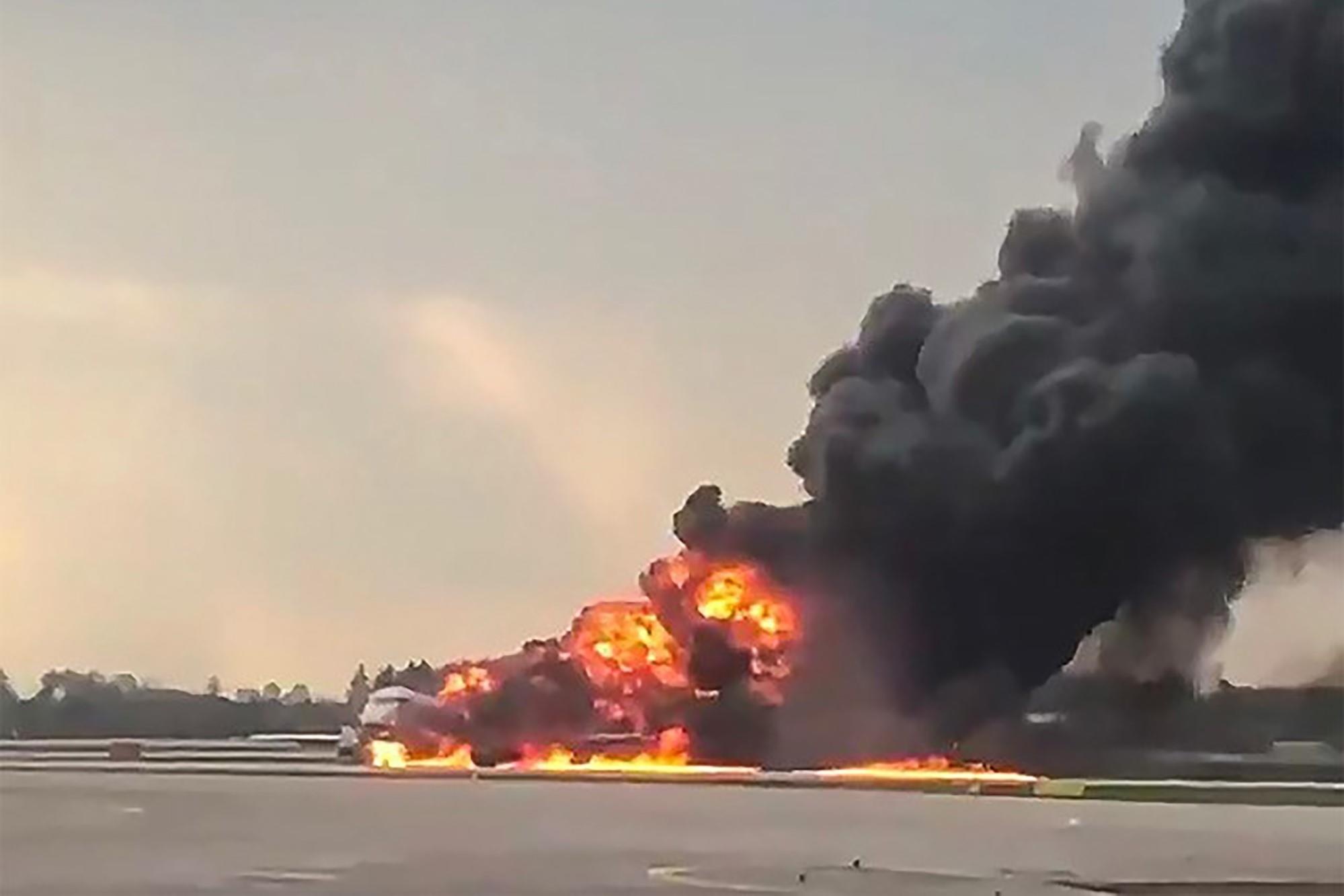 Hanh khach hoang loan chay khoi may bay Nga dang boc chay hinh anh