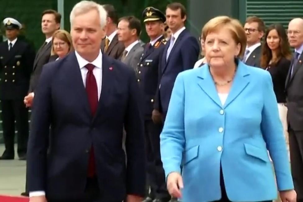 Thu tuong Merkel lai run lay bay duoi troi nang hinh anh