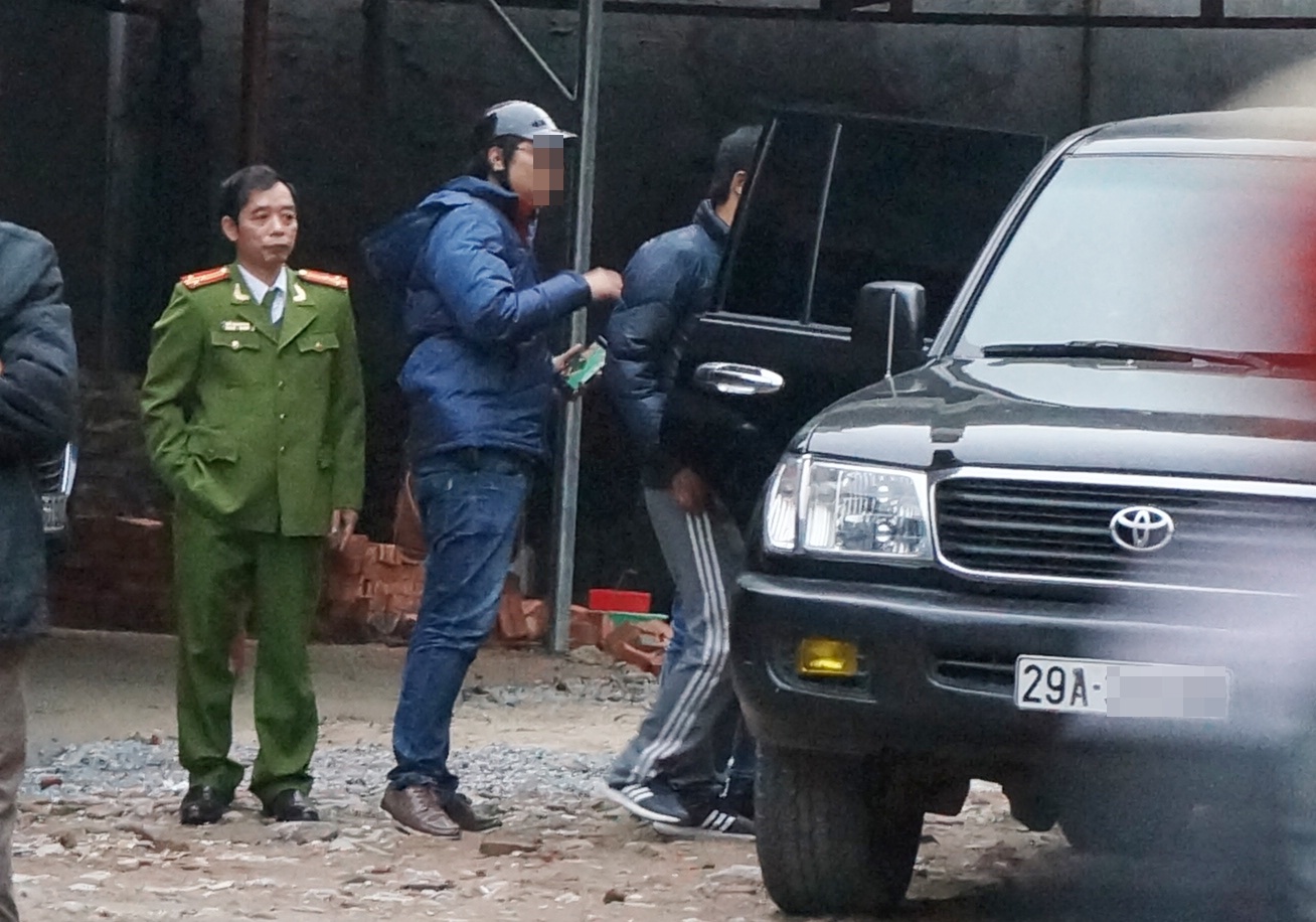 Cảnh sát đưa người liên quan lên xe ôtô. Ảnh: Việt Đức.