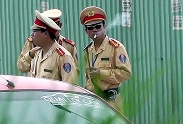 Cam cong an deo kinh den, dut tay tui quan khi lam nhiem vu hinh anh