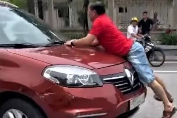 Cong an lam viec voi tai xe va nguoi dan ong bam vao capo oto tren pho hinh anh