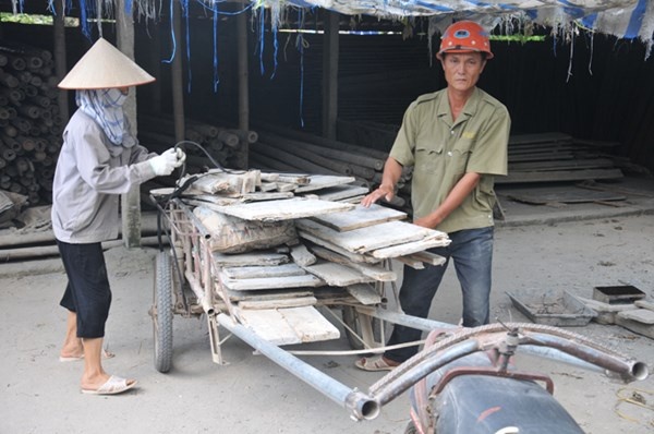Vợ chồng ông Nguyễn Đức cho cốp-pha lên xe tới công trình đang xây dựng.