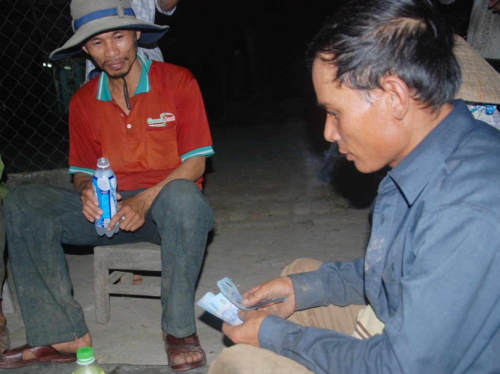 Người dân đếm tiền sau khi bán dưa cho các tình nguyện viên.