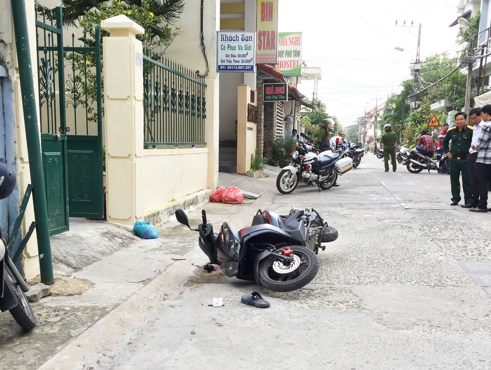 Dép và xe máy nạn nhân ngay tại cổng nhà. Ảnh: Đ. Nguyên.