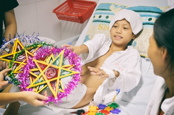 Hồ Sỹ Quý hân hoan đón nhận quà trung thu từ nhóm thiện nguyện. (Ảnh: Chạm)