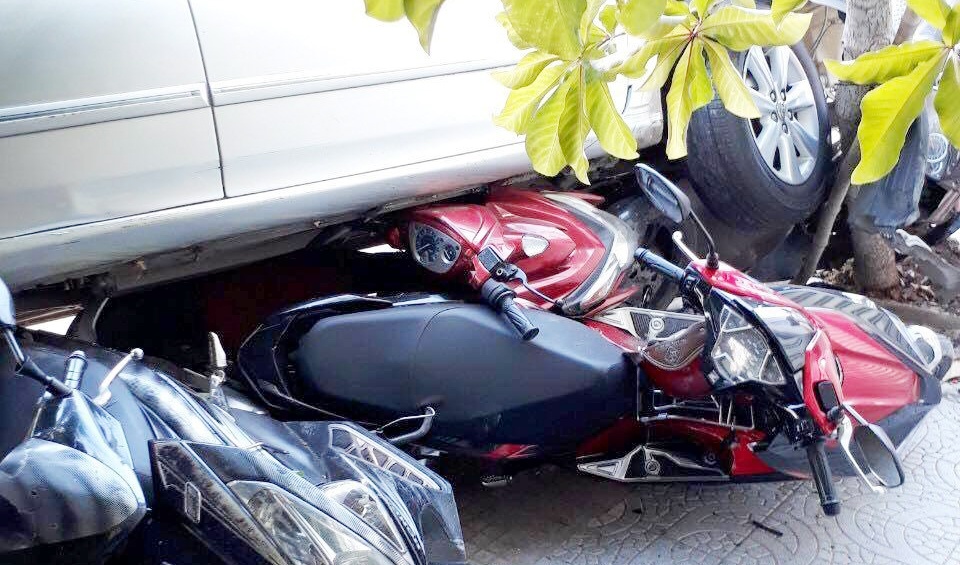 Lui oto tu nha ra duong, nu tai xe cuon 4 xe may vao gam hinh anh