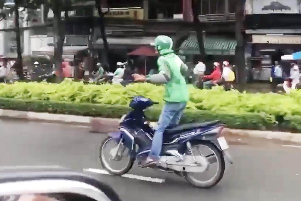 Thanh nien mac ao GrabBike tha tay phong xe may tren duong Sai Gon hinh anh