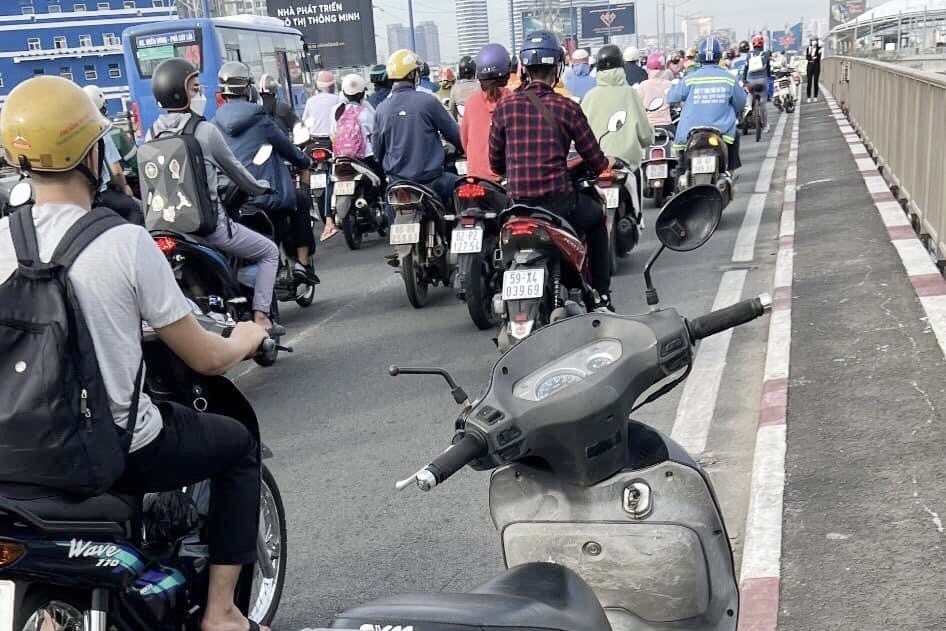 Bo lai xe may va doi dep, nguoi dan ong nhay song Sai Gon hinh anh