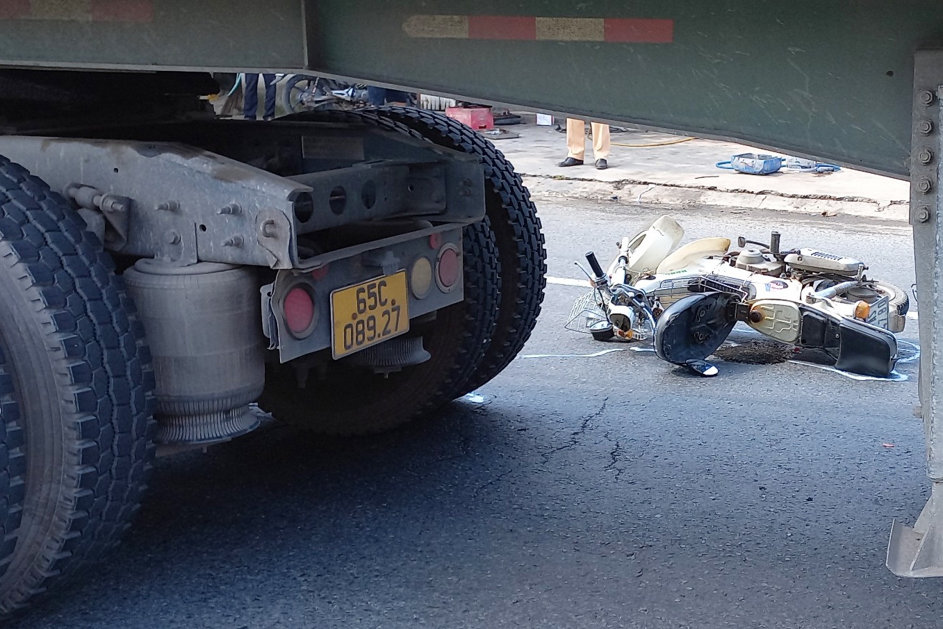 Nguoi phu nu bi cuon vao gam xe container hinh anh