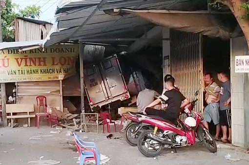 Xe tai va cham oto khach roi tong sap nha dan hinh anh