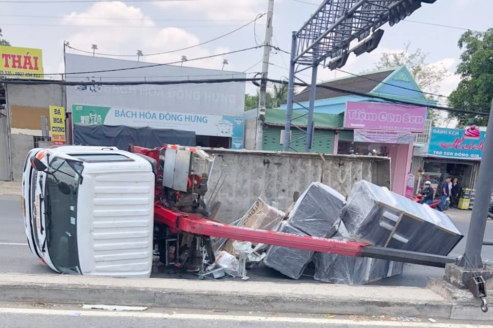 Xe tai keo gay tru dien, lat ngang tren quoc lo 1 hinh anh