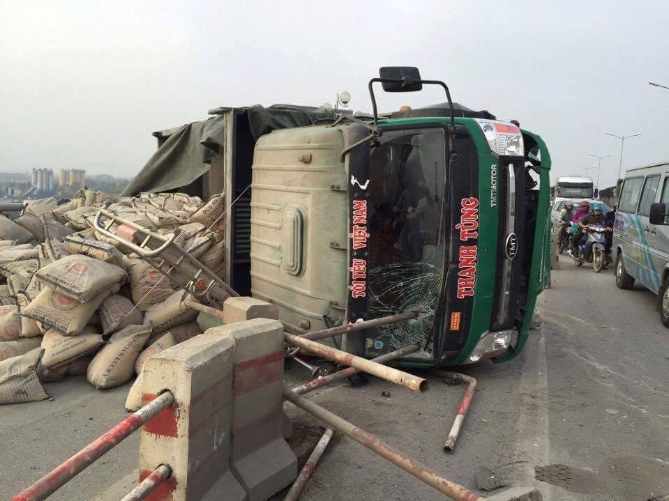 Canh sat dung oto chuyen xi mang tren xe tai bi lat giua cau hinh anh