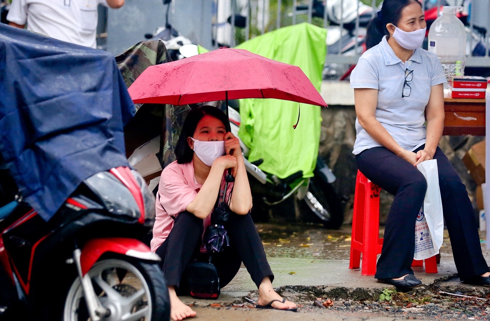 Phu huynh ngoi doi con duoi mua o TP.HCM hinh anh