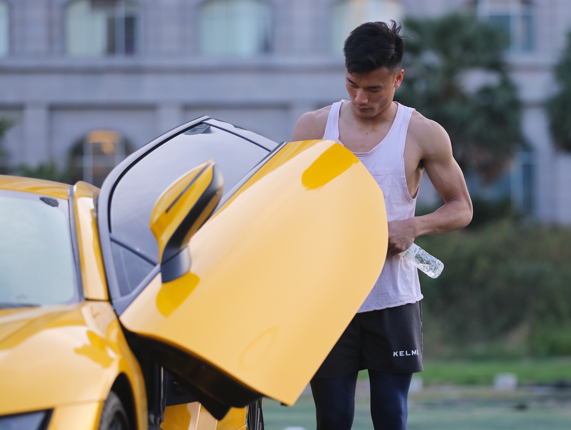 Bui Tien Dung di xe the thao den san tap cung dong doi hinh anh