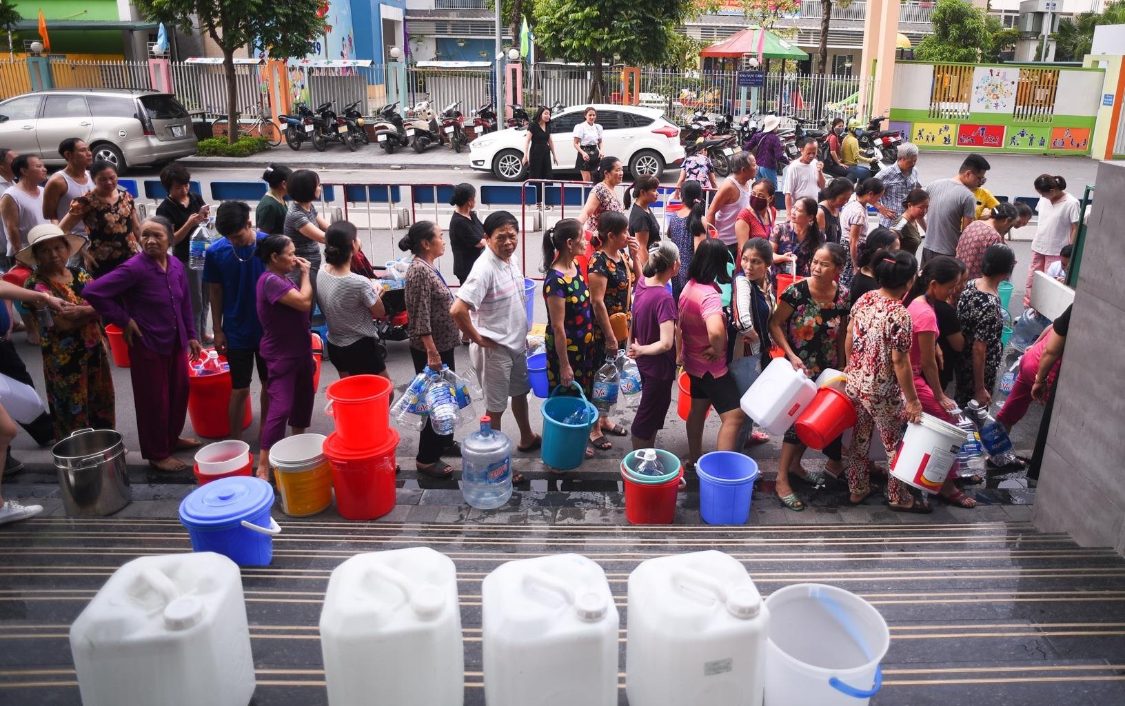 Nguoi Ha Noi mang xoong noi, xe noi xep hang cho nuoc sach hinh anh