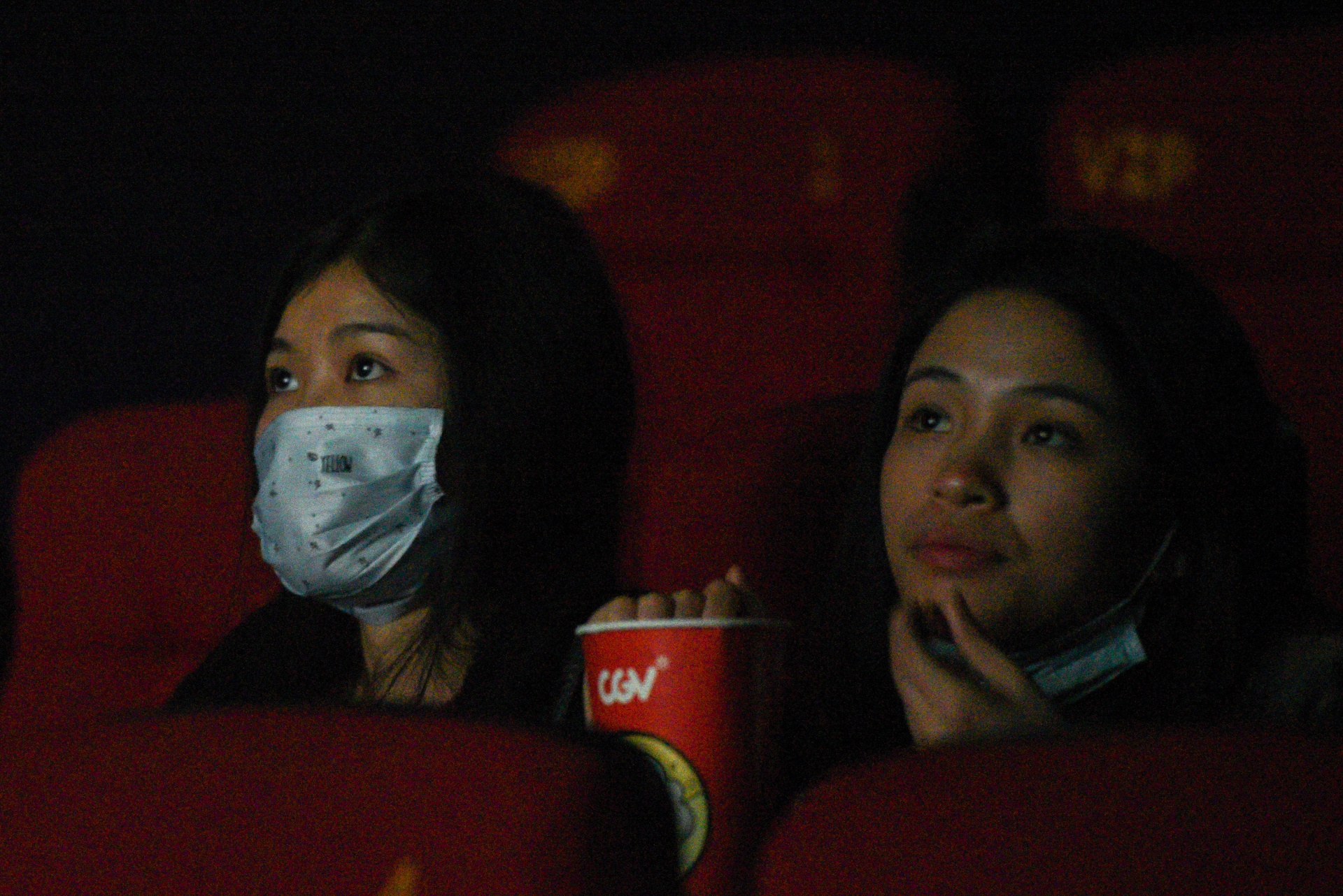 Khach xem phim trong rap voi khau trang deo kin mat hinh anh