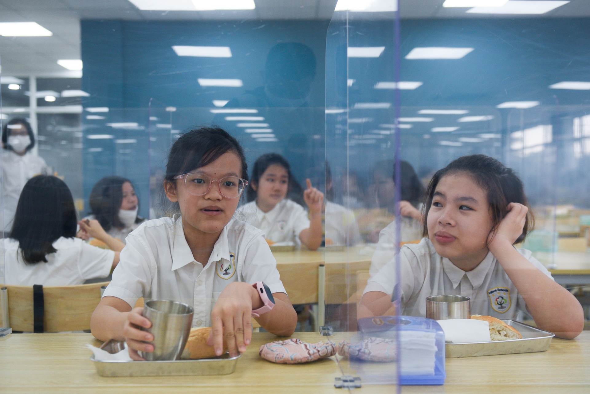 Hoc sinh ngoi an qua vach ngan trong ngay dau tro lai lop hinh anh