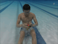 Chang trai lan xuong nuoc xoay rubik hinh anh