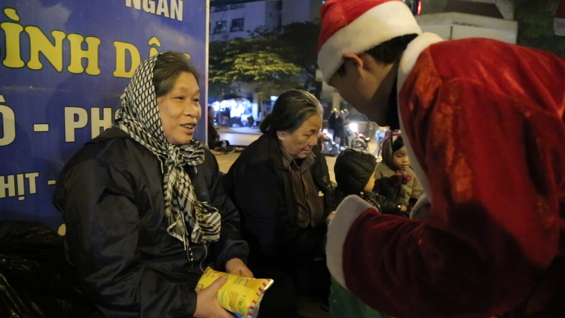 Nhom ban tre tang qua Noel cho nguoi vo gia cu giua dem lanh hinh anh