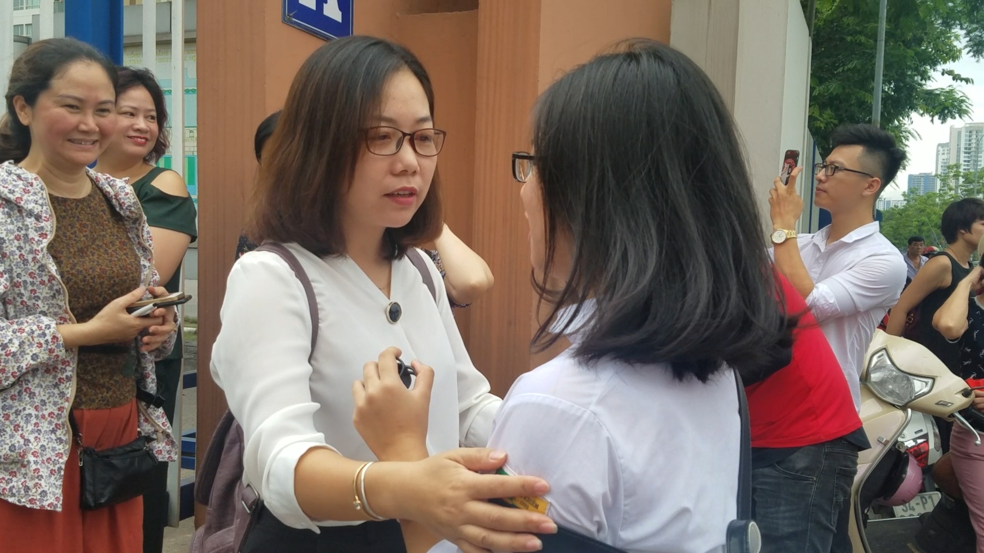 Co giao chu nhiem om hoc tro truoc cong truong thi hinh anh