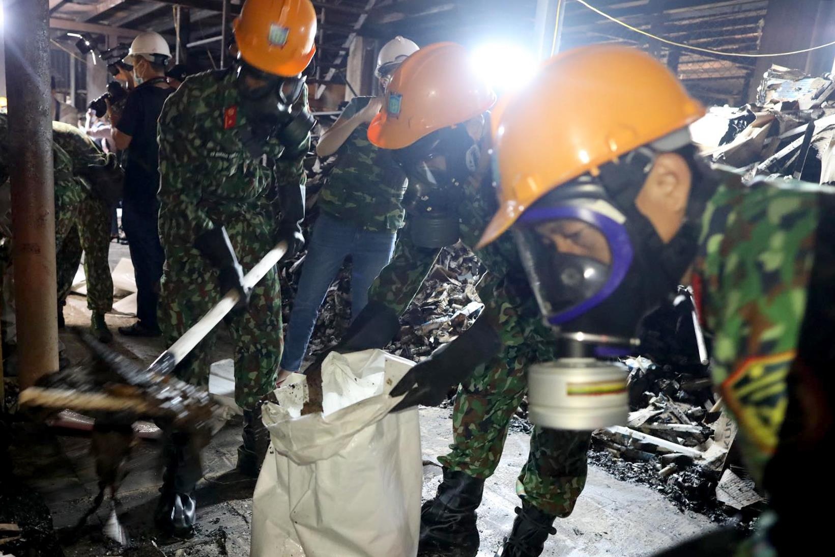 Quan nhan deo mat na tay doc hien truong vu chay Rang Dong hinh anh