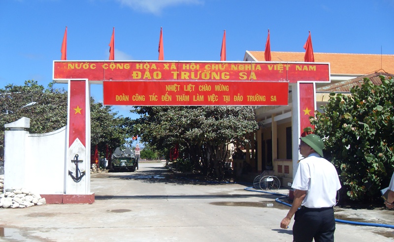 Cờ đỏ sao vàng rực rỡ trên nền trời xanh ngát tại cổng chào ở đảo Trường Sa lớn.