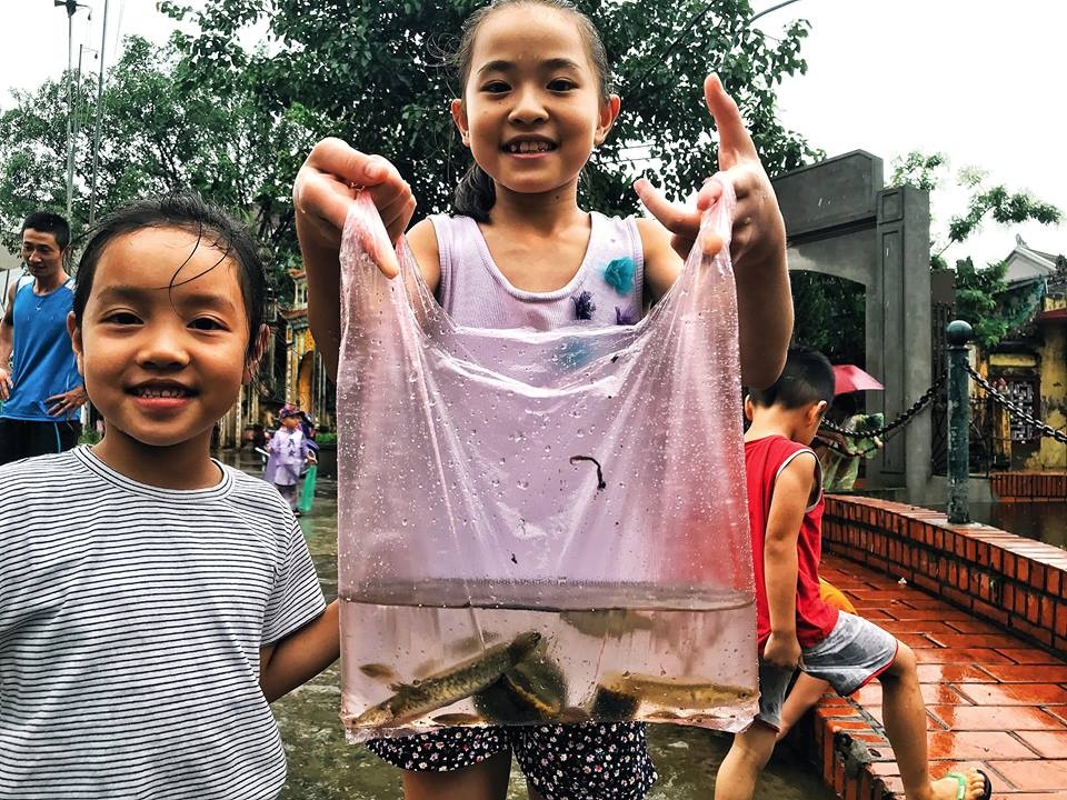 Tre con Ha Noi mang ro, ra bat ca giua pho ngay mua ngap hinh anh
