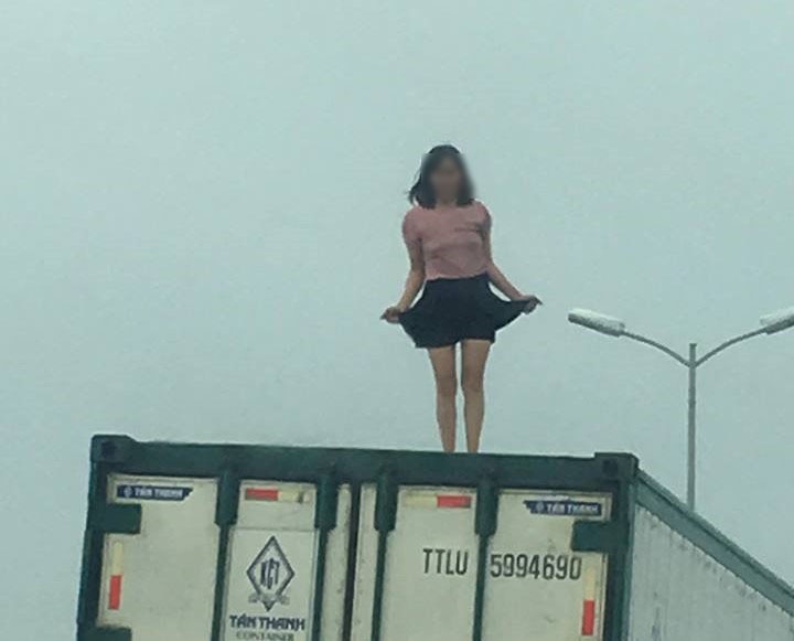 Nguoi phu nu mac vay ngan nhay mua tren thung xe container hinh anh