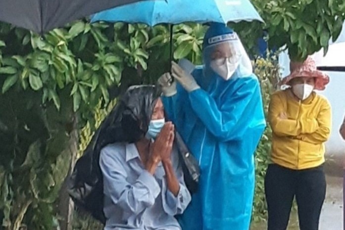Nu tinh nguyen vien o TP.HCM cam o che cho cu gia duoi troi mua lon hinh anh