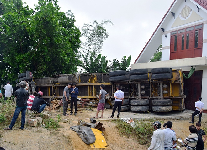 Xe dau keo lat ngang truoc nha dan, tai xe mac ket trong cabin hinh anh