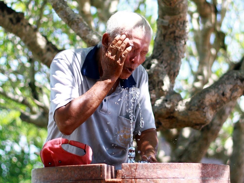 Nguoi dan co do mac vong, tiep nuoc trong cong vien tranh nong hinh anh