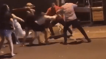 Hai nhom nam nu hon chien giua duong hinh anh