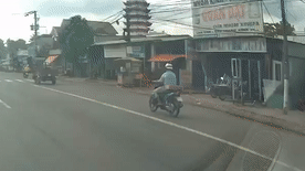 Nguoi chay xe may tong xe 3 banh dung giua duong hinh anh