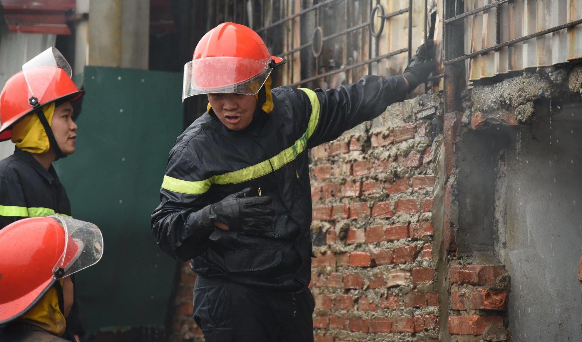 Canh sat pha tuong de tiep can dam chay o cua hang thit cho hinh anh