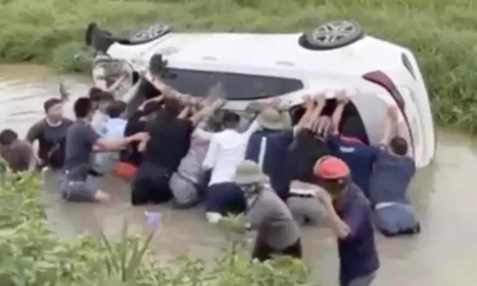 Giai cuu 2 chau be trong oto lat ngua duoi muong nuoc o Ha Noi hinh anh