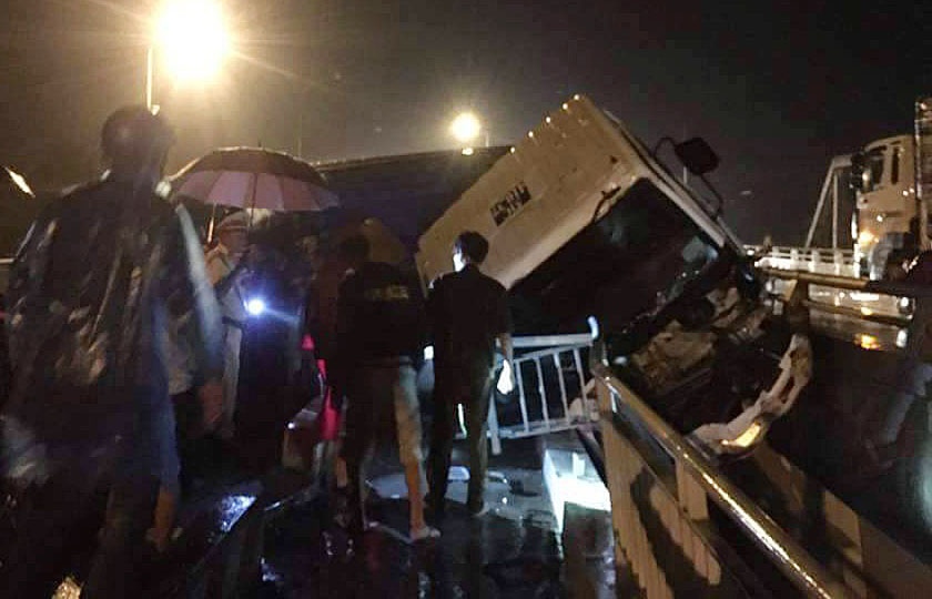 Xe dau keo lat ngang mac ket tren thanh cau, tai xe may man thoat chet hinh anh