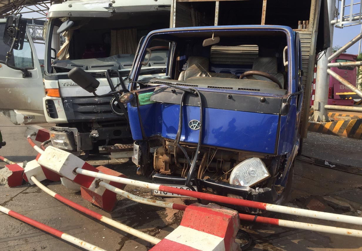 Hai xe tai dam hong dai phan cach tram thu phi BOT hinh anh