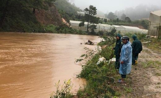 Nguoi dan ong bi nuoc cuon khi bang qua dap tran hinh anh