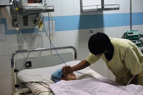 Anh Vương đang chăm sóc chị Huệ tại bệnh viện.