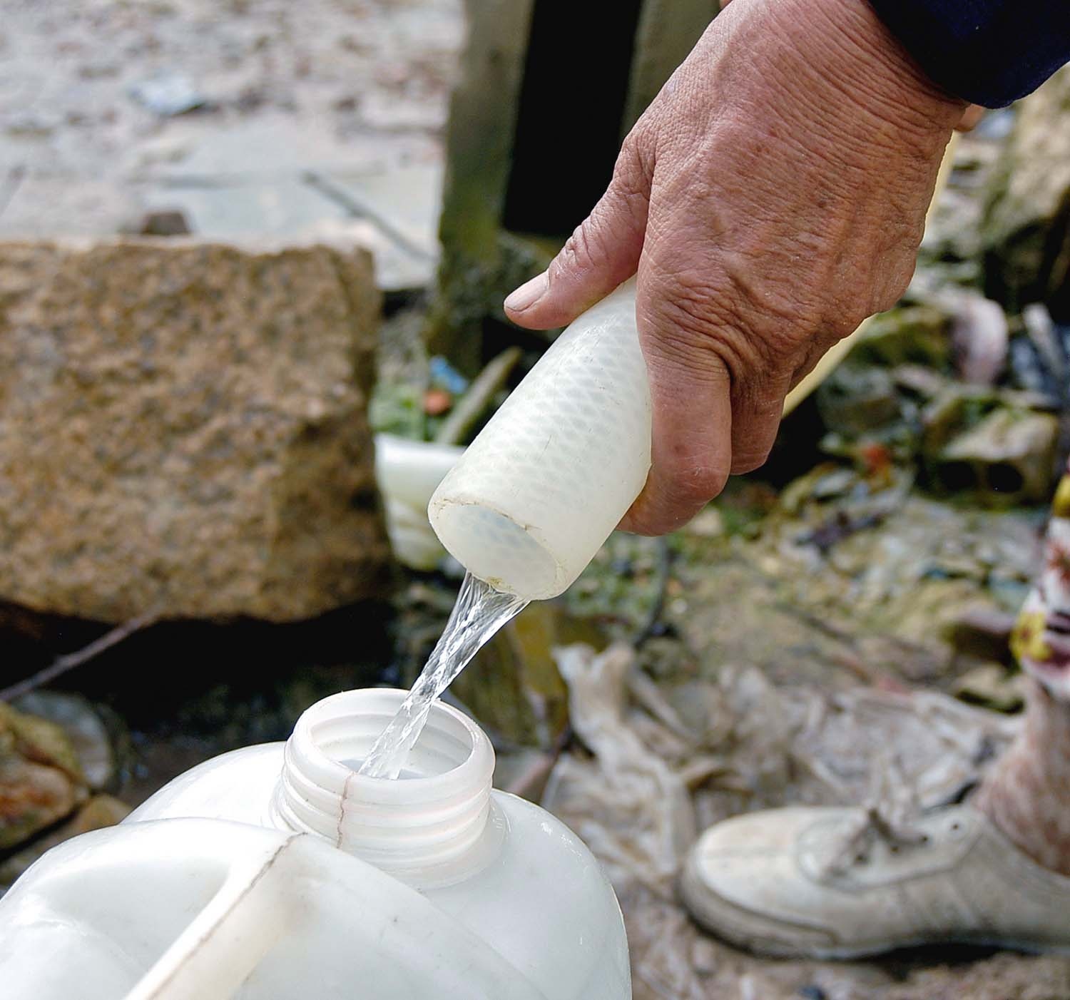 Có những hôm họ phải chắc chiu từng dòng nước nhỏ vào bình để mang về.