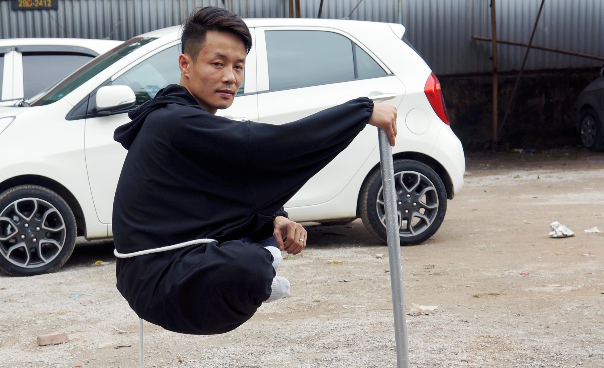 Thanh nien ngoi lo lung tren khong o bai do oto hinh anh