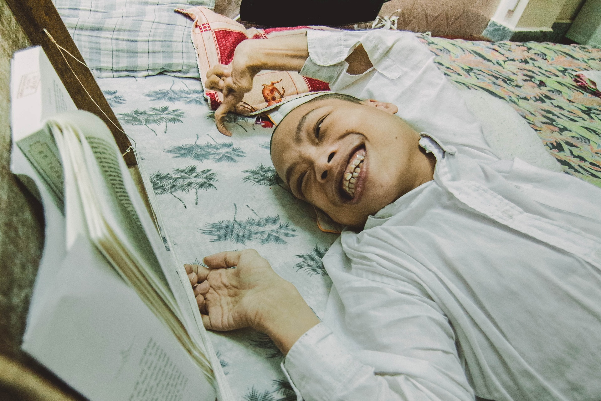 Chang trai ca cuoc doi gan chat tren chiec giuong doc sach hinh anh