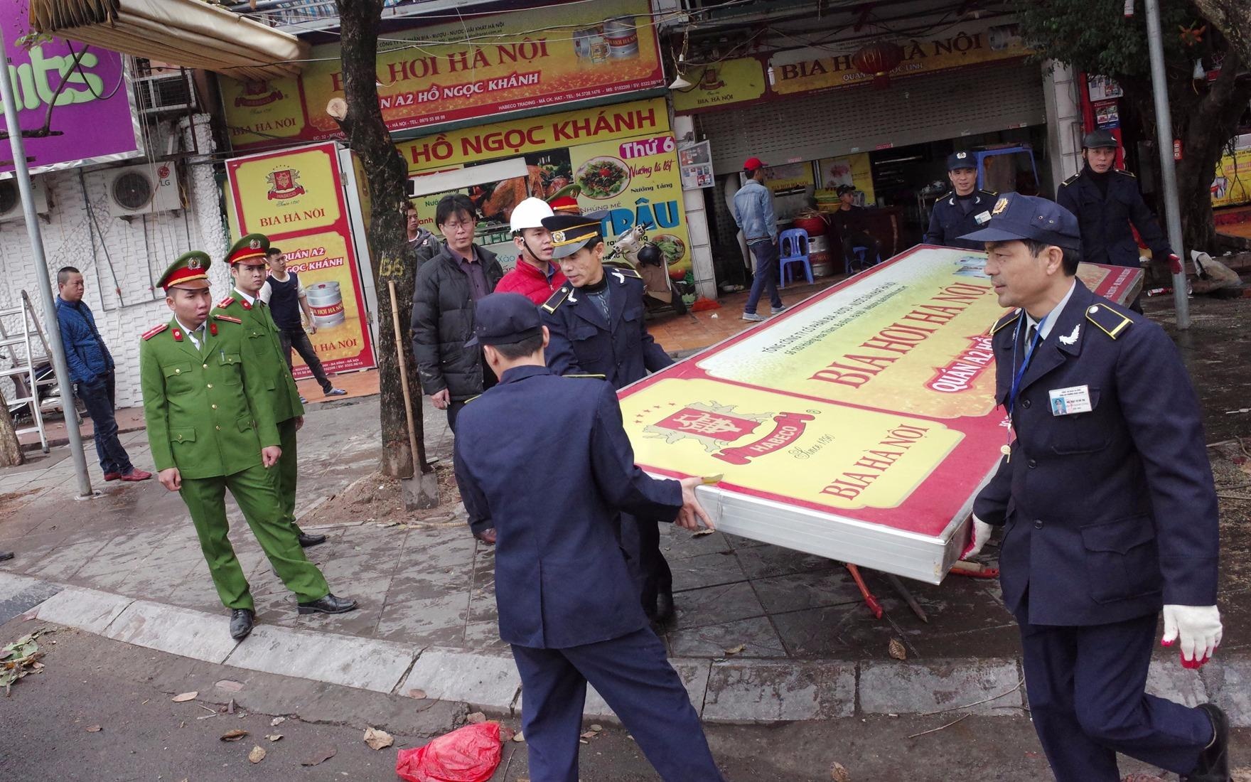 Canh sat go sach bien quang cao cua quan bia lan via he hinh anh