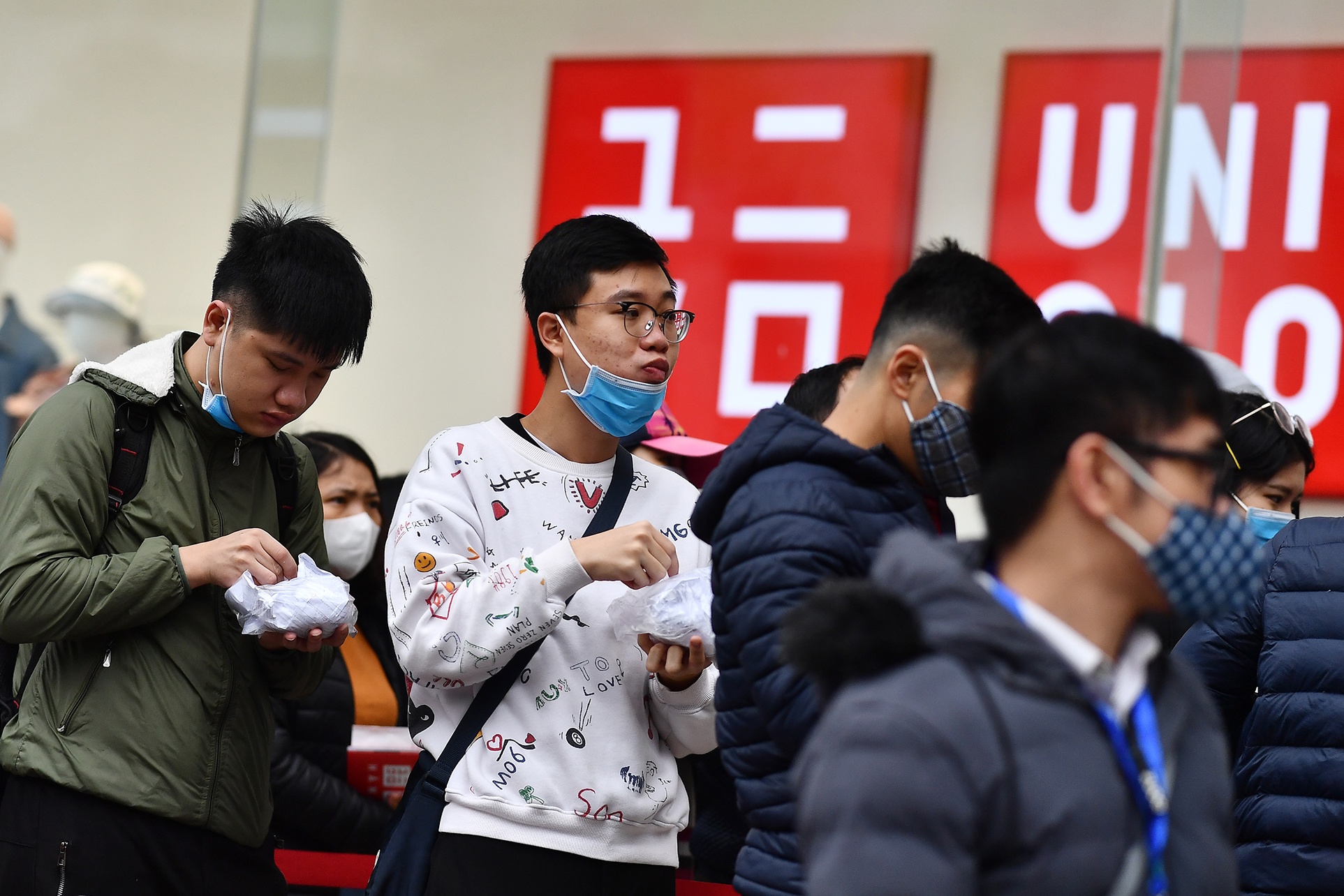Deo khau trang chen lan mua hang Uniqlo o Ha Noi ngay khai truong hinh anh